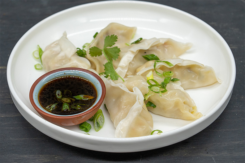 Chicken Lemongrass Potstickers with dipping sauce, an appetizer often served with Barclay-Kingston, Cherry Hill Pad Thai.